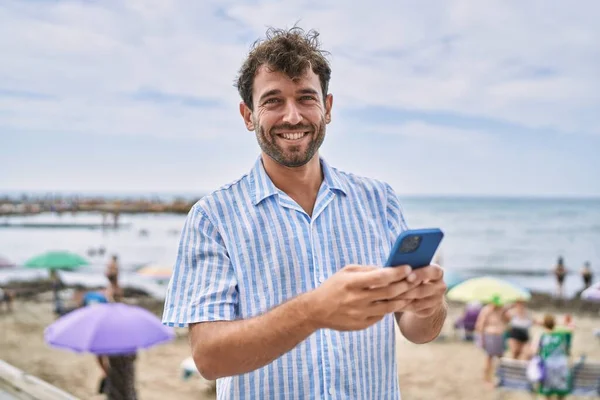 Genç Spanyol Adam Sahilde Akıllı Telefon Kullanarak Mutlu Bir Şekilde — Stok fotoğraf