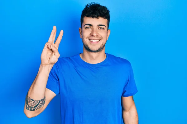 Fiatal Spanyol Férfi Alkalmi Kék Pólóban Mutatva Mutatva Hármas Számú — Stock Fotó