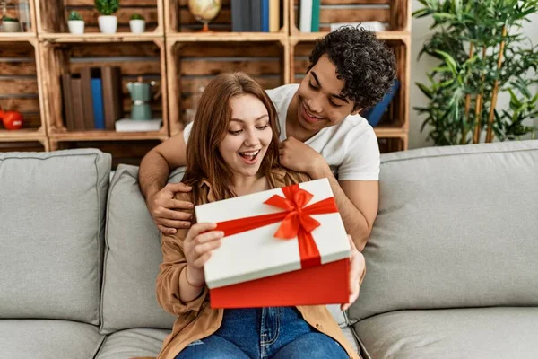 Jovem Casal Sorrindo Feliz Sentado Sofá Surpresa Com Presente Aniversário — Fotografia de Stock