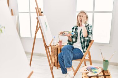 Sanat stüdyosunda tuvale resim yapan genç bir sanatçı. Yüzünün yarısını, gözünü ve ağzını eliyle kapatmaktan yorulmuş. Yüzüm acıyor.. 