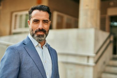 Orta yaşlı işadamı şehirde mutlu mesut dikilirken.