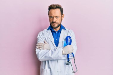 Doktor üniforması giyen orta yaşlı bir adam bilgisiz ve kafası karışık bir ifade takınıyor. şüphe kavramı. 