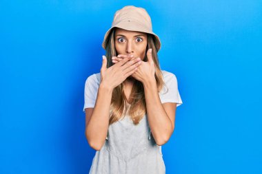 Kaşif şapkası takan güzel İspanyol kadın yanlışlıkla elleriyle ağzını kapatırken şok oldu. gizli kavram. 
