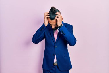 Genç İspanyol bir adam iş elbisesi giyiyor ve kravatını bağlıyor. Baş ağrısı, çaresiz ve stresli. Çünkü acı ve migren. Eller başının üstünde.. 