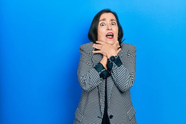 Orta yaşlı İspanyol kadın iş kıyafetleri giyip bağırıyor ve boğularak ölüyor çünkü boğularak can çekişiyor. Sağlık problemi. Boğulma ve intihar konsepti. 