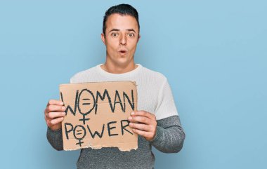 Elinde kadın güç pankartı tutan yakışıklı genç adam ağzı açık kalmış, korkmuş ve hayrete düşmüştü. 
