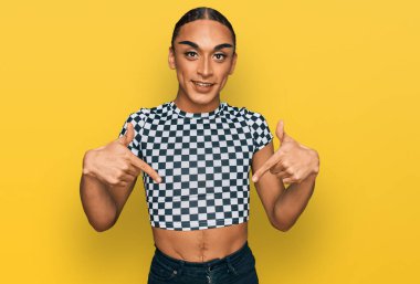 Makyaj yapan, uzun saçlı, modern kıyafetler giyen, kendine güvenen, gülümseyen, kendini gururlu ve mutlu gösteren İspanyol bir transseksüel.. 