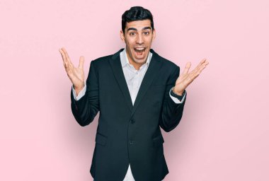 İş kıyafetleri giymiş yakışıklı bir İspanyol çılgın ve başarıyı kollarını kaldırıp heyecanla haykırarak kutluyor. Kazanan konsept 