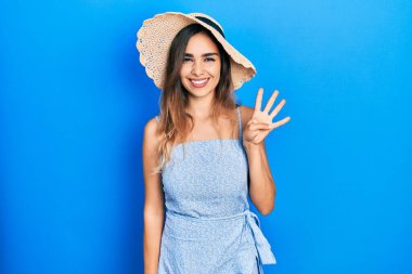 İspanyol asıllı genç kız, yaz şapkası takıyor ve parmaklarını dört numarayı göstererek gülümsüyor. Kendinden emin ve mutlu.. 