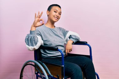 Tekerlekli sandalyede oturan, gülümseyen güzel İspanyol kadın el ve parmaklarıyla 