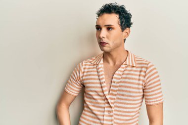 Makyaj yapan yakışıklı, rahat gömlekli, gergin ve sinirli, kafası karışık, şaşırmış ve sinirli bir adam. 