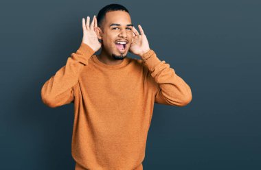 Genç Afro-Amerikalı günlük kıyafetler giymiş neşeli gülümseyen ve elleri havada bir böceği dikizleyen bir adam. Şaşırdım ve çıktım. 