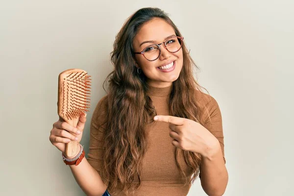 Menina Hispânica Jovem Segurando Cabelo Pente Sorrindo Feliz Apontando Com — Fotografia de Stock