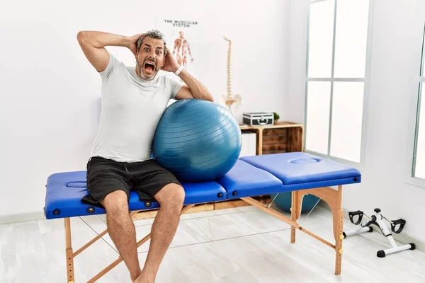 Latynos Średnim Wieku Klinice Rekonwalescencji Bólu Trzymając Pilates Piłkę Szalony — Zdjęcie stockowe