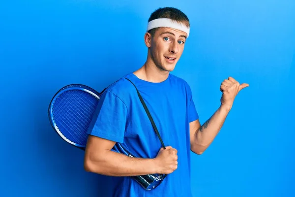 Joven Hombre Caucásico Sosteniendo Bolsa Tenis Apuntando Pulgar Hacia Lado —  Fotos de Stock