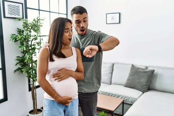 Joven Interracial Pareja Esperando Bebé Tocando Embarazada Vientre Mirando Reloj — Foto de Stock
