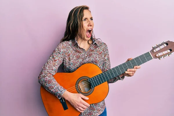 Young Blonde Woman Playing Classical Guitar Angry Mad Screaming Frustrated — Stock Photo, Image