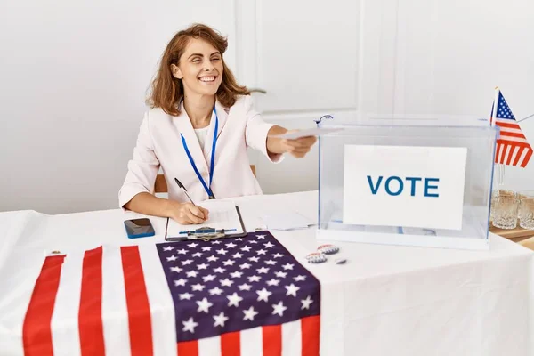 Young american politic party worker smiling happy  holding vote at electoral college.