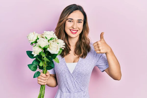 Menina Hispânica Jovem Segurando Flores Sorrindo Feliz Positivo Polegar Para — Fotografia de Stock