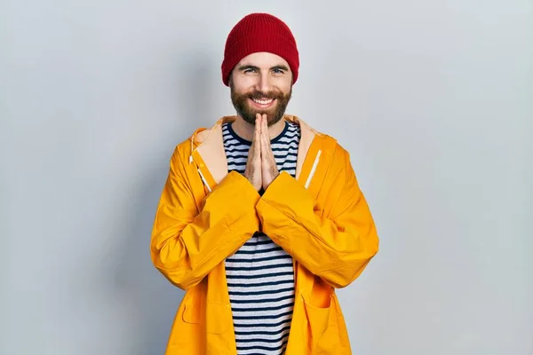 Hombre Caucásico Con Barba Vistiendo Impermeable Amarillo Rezando Con Las —  Fotos de Stock