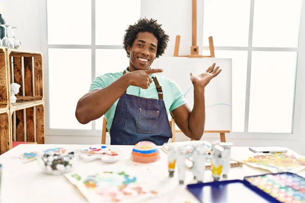 Jovem Americano Africano Sentado Mesa Estúdio Arte Espantado Sorrindo Para — Fotografia de Stock