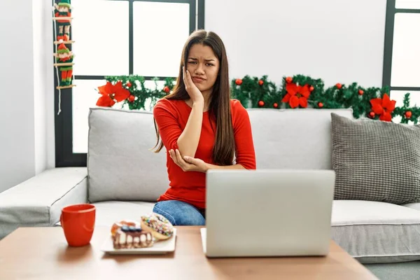 Jovem Morena Usando Laptop Sentado Sofá Natal Pensando Que Parece — Fotografia de Stock