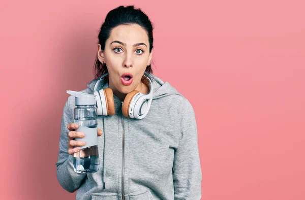 Junge Hispanische Frau Sportbekleidung Mit Wasserflasche Über Kopfhörer Verängstigt Und — Stockfoto