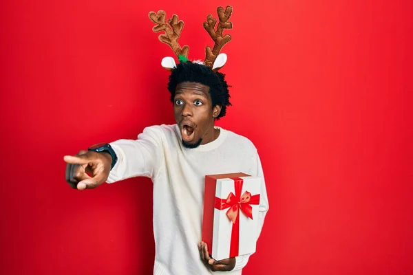 Junger Afrikanisch Amerikanischer Mann Mit Hirsch Weihnachtsmütze Der Geschenk Hält — Stockfoto