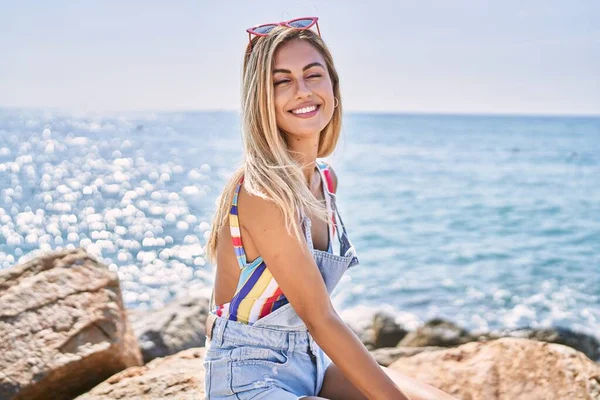 Joven Chica Rubia Sonriendo Feliz Sentado Roca Playa —  Fotos de Stock