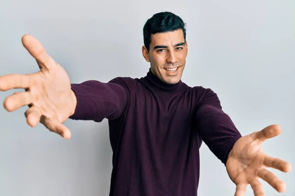 Hombre Hispano Guapo Con Jersey Cuello Alto Mirando Cámara Sonriendo —  Fotos de Stock