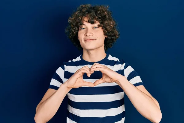 英俊的年轻人穿着休闲的条纹T恤 微笑着用双手做着心形符号 浪漫的概念 — 图库照片