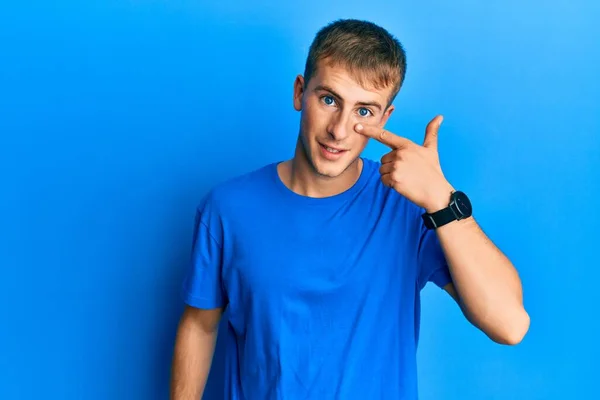 年轻的高加索人 身穿休闲的蓝色T恤 手指头对着鼻子 笑容满面 美的概念 — 图库照片