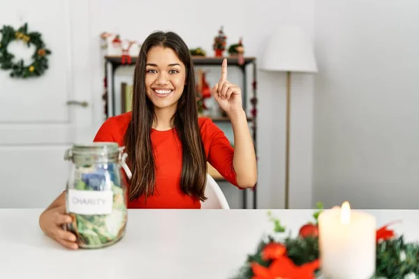 Junge Brünette Frau Weihnachten Hält Charity Glas Mit Geld Hause — Stockfoto