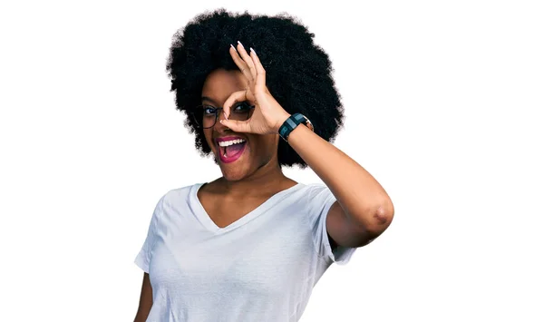 年轻的非洲裔美国女人穿着休闲的白色T恤 手握微笑 用手指看着幸福的脸 做着一个不错的手势 — 图库照片