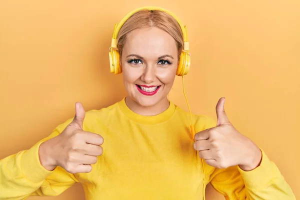 Young Blonde Woman Listening Music Using Headphones Success Sign Doing — Stock Photo, Image