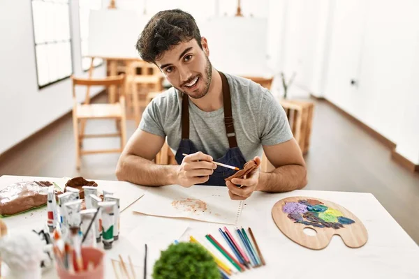 Young Hispanic Artist Man Smiling Happy Painting Pottery Art Studio — Stock Photo, Image