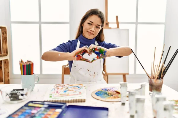 在艺术工作室里的年轻的黑发女人 手绘着彩绘的手 带着爱的微笑 手绘着心形符号 浪漫的概念 — 图库照片