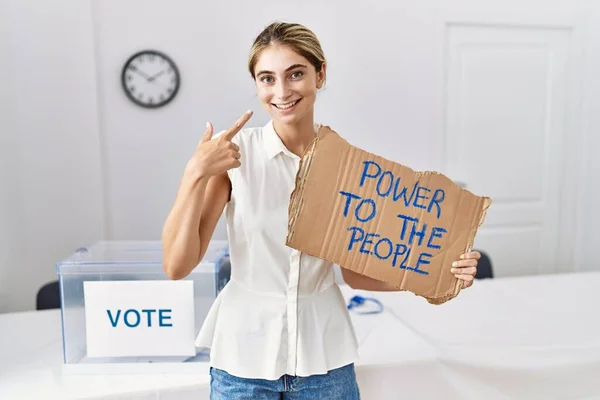 Młoda Blondynka Wyborach Politycznych Trzyma Władzę Sztandarze Wskazując Palcem Uśmiechniętą — Zdjęcie stockowe