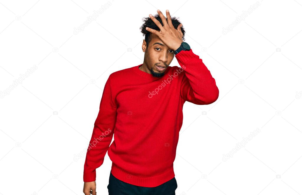 Young african american man with beard wearing casual winter sweater surprised with hand on head for mistake, remember error. forgot, bad memory concept. 