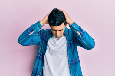 Yakışıklı İspanyol adam gündelik kıyafetler giyiyor. Baş ağrısı çekiyor, çaresiz ve stresli. Çünkü acı ve migren. Eller başının üstünde.. 
