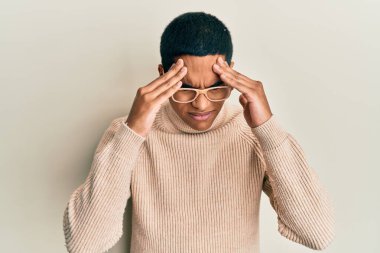 Balıkçı yaka kazak giyen ve eli kafasında gözlük takan genç, yakışıklı İspanyol bir adam. Stresten baş ağrısı çekiyor. migren ağrısı. 