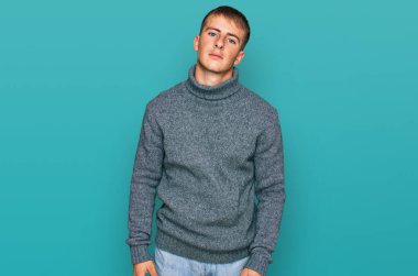 Sıradan kıyafetler giyen genç sarışın adam yüzünde ciddi bir ifadeyle rahatlamış. Basit ve doğal bir şekilde kameraya bakıyorsun.. 