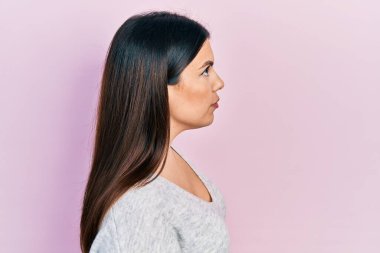 Latin kökenli genç bir kadın rahat bir görünüm ve kendine güvenen bir gülümseme takınıyor.. 