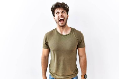 Hispanik adam izole edilmiş beyaz arka planda öfkeli ve kızgın bir şekilde bağırıyor öfkeyle bağırıyor. öfke ve agresif konsept. 