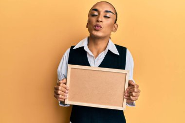 Makyajlı, uzun saçlı, elinde boş bir mantar mantar olan İspanyol bir adam öpüşme sahnesine bakıp sevimli ve seksi görünmeye çalışıyor. aşk ifadesi. 