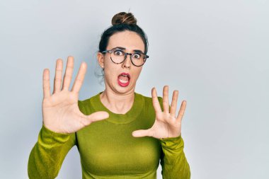 Günlük kıyafetler ve gözlük takan genç İspanyol kız korku ifadesinden korkuyor ve dehşete düşüyor. El hareketlerini bırak, şok içinde bağır. panik konsepti. 