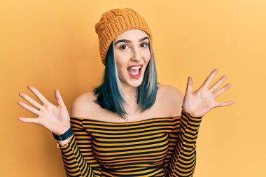 Yün şapka takan genç bir kız çılgın ve başarıyı kollarını kaldırıp heyecanla haykırarak kutluyor. Kazanan konsept 