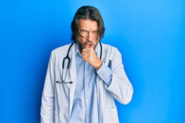 Doktor üniforması ve steteskop giyen orta yaşlı yakışıklı bir adam kendini iyi hissetmiyor ve soğuk algınlığı veya bronşitin belirtisi olarak öksürüyor. sağlık hizmeti kavramı. 