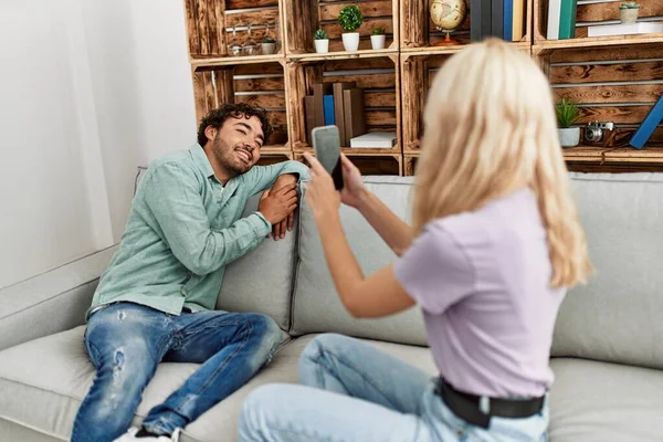 Mujer Joven Haciendo Foto Novio Usando Teléfono Inteligente Casa — Foto de Stock