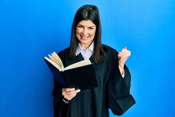 Young Hispanic Woman Wearing Judge Uniform Reading Book Screaming Proud — Stock Photo, Image